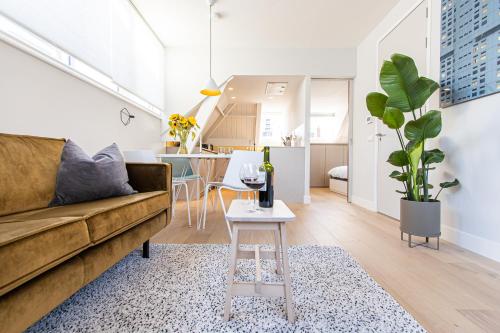 a living room with a couch and a table at OHotellMe City Apartments Rotterdam in Rotterdam