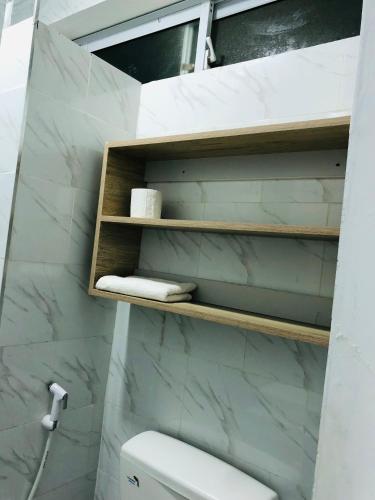 a bathroom with a white toilet and marble walls at Queens Luxury Studio Mombasa in Mombasa