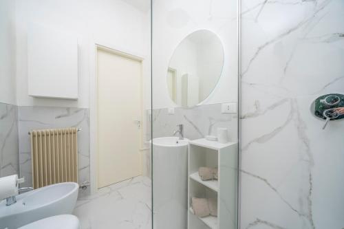 a white bathroom with a sink and a mirror at Cividale Medieval Town Apartment in Cividale del Friuli