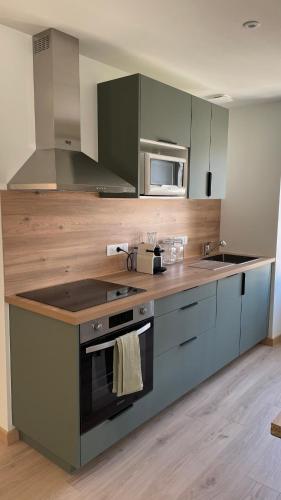 une cuisine avec un évier et une cuisinière four supérieur dans l'établissement Duplex au cœur de Châteauroux, à Châteauroux
