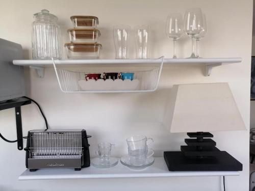 une étagère avec des verres et une lampe sur une table dans l'établissement Top floor parisian apartment with terrace, à Paris