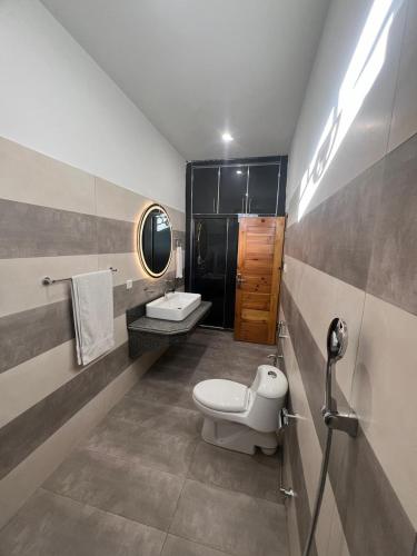 a bathroom with a toilet and a sink and a mirror at ISLE OF HIGHLAND TOURS Guest House in Gilgit
