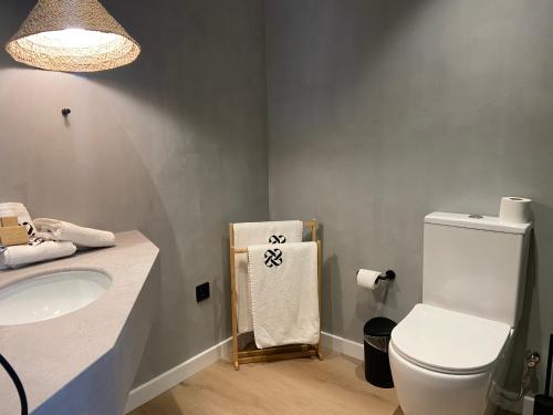a bathroom with a toilet and a sink and a towel at Calendula Hotel & Apartaments in Sant Feliu de Guixols
