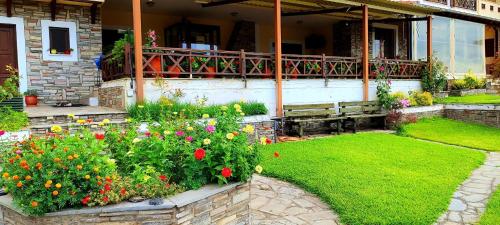 a garden with flowers in front of a house at Philoxenia Hotel in Paranesti