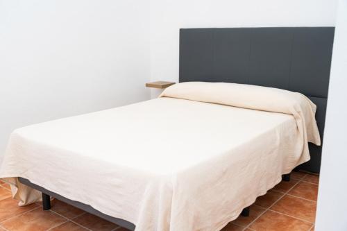a bedroom with two beds with white sheets at Centro apartamento 2-D in Huelva
