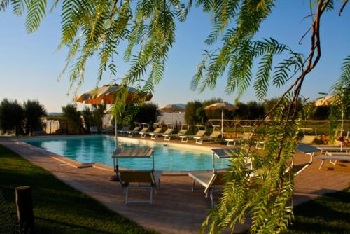 a swimming pool with lounge chairs and umbrellas at Agriturismo Le Rose in Pescia Romana