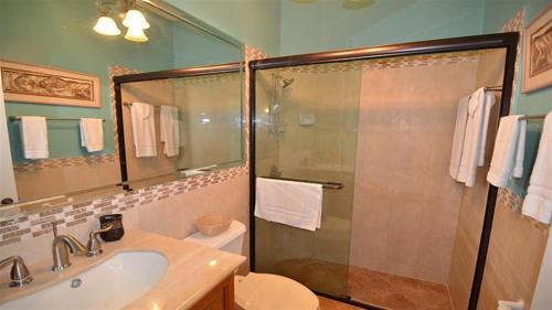 a bathroom with a shower and a toilet and a sink at Spicy Hill Villa in Port Antonio