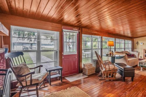 a living room with a red door and chairs at Nature's Nest Lake House in Lake Wales