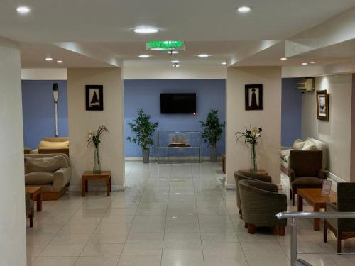 a lobby with a waiting room with couches and a tv at Hotel Centro Naval in Buenos Aires
