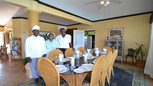 a group of people standing around a dining table at Spicy Hill Villa in Port Antonio