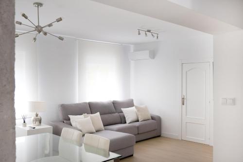 een witte woonkamer met een bank en een tafel bij Corazón Cuatro in Jaén