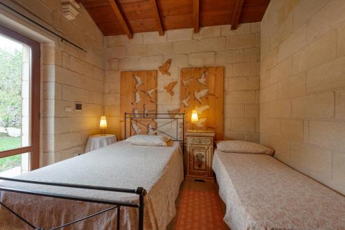 a bedroom with two beds and a window at Masseria Copertini in Vernole