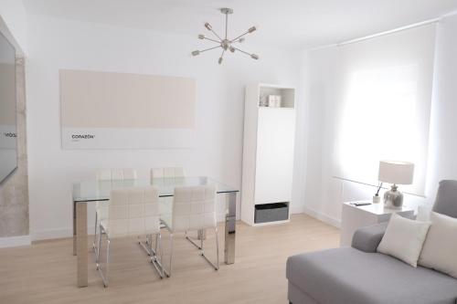 een eetkamer met een tafel, stoelen en een bank bij Corazón Cuatro in Jaén