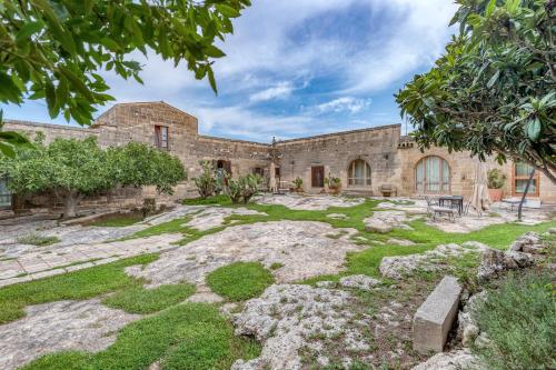 an exterior view of a stone building with a yard at Masseria Copertini in Vernole