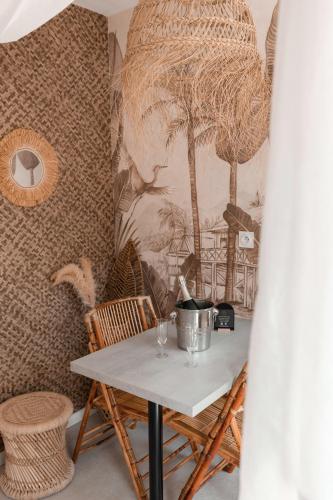une table dans une pièce avec un mur avec une fresque murale dans l'établissement L'expérience LOVE ROOM, à Saint-Jean-Bonnefonds