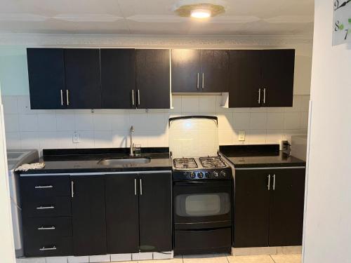 a kitchen with black cabinets and a stove top oven at Guadual 101 in La Victoria