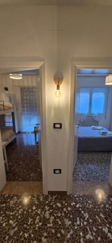 un corridoio che conduce a una camera da letto con letto e luce di Ca' Olivo a Mogliano Veneto