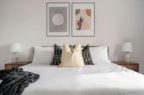 a bedroom with a white bed with pillows at Dino Roar I Sleeps 12 I New in Drumheller
