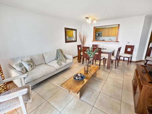 a living room with a couch and a table at Marbella Country Club in Maitencillo