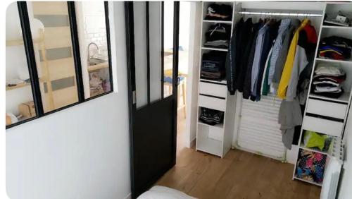 Cette chambre comprend un placard avec une porte et un miroir. dans l'établissement Charmante maison de ville avec terasse intime, à La Rochelle