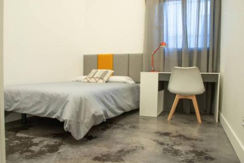 Un dormitorio con una cama, un escritorio y una silla. en Stunning Apartment Pueblo Nuevo, en Madrid