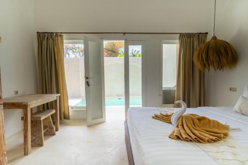 a bedroom with a bed with a towel on it at Wellhouse Villas in Nusa Lembongan