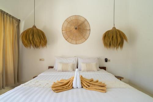 a bedroom with a white bed with towels on it at Wellhouse Villas in Nusa Lembongan
