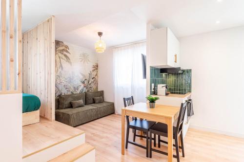 une cuisine et un salon avec une table et un canapé dans l'établissement Le cozy loft Annecy, à Annecy