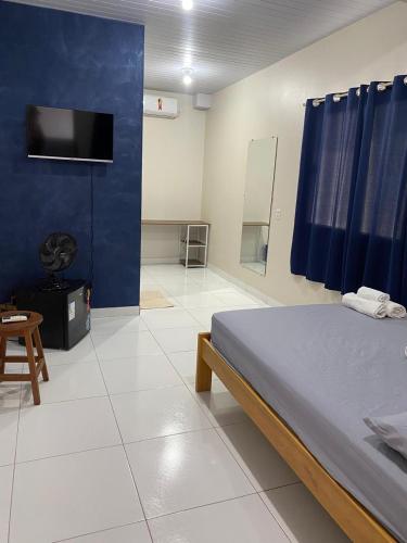 a bedroom with a bed and a blue wall at Temporada BHS Quarto 1 in Barreirinhas