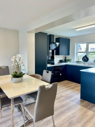 a kitchen and dining room with a table and chairs at 6 Millstone Grove in Portstewart