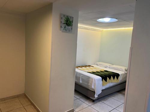 a small bedroom with a bed in a room at APARTAMENTO cerca al UNICO in La Victoria