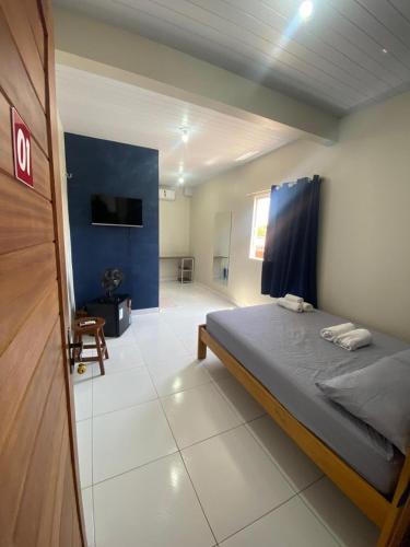 a bedroom with a large bed and a room with a roomswersswersswersswers at Temporada BHS Quarto 1 in Barreirinhas