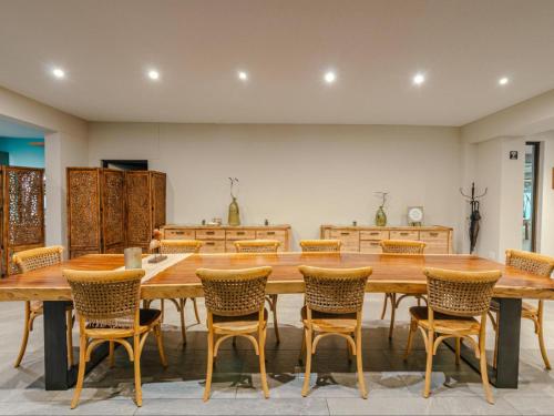 a large dining room with a large wooden table and chairs at Little Forest Garden Retreat in Windhoek