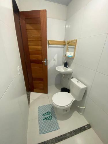a small bathroom with a toilet and a sink at Temporada BHS Quarto 3 in Barreirinhas