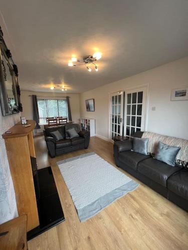 a living room with a black couch and a white rug at Marguerite Retreat in Newcastle