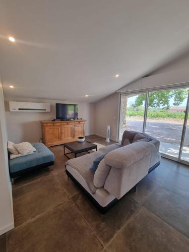 un salon avec un canapé et une table dans l'établissement Une Nuit au Cœur d'un Vignoble Provençal Piscine, à Cotignac