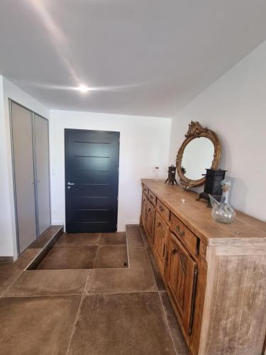 une pièce avec une commode en bois et une porte noire dans l'établissement Une Nuit au Cœur d'un Vignoble Provençal Piscine, à Cotignac