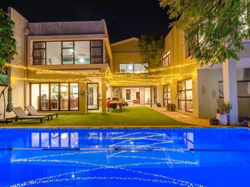 a house with a swimming pool at night at Little Forest Garden Retreat in Windhoek