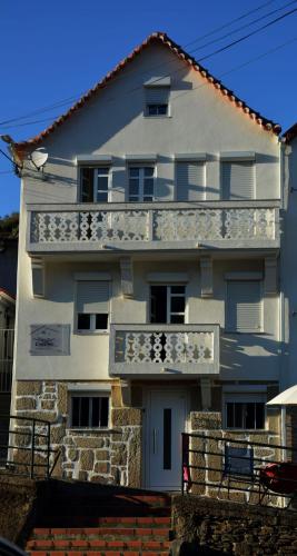 a white building with a balcony on the side of it at Casa da Ti Cristina in Pomares