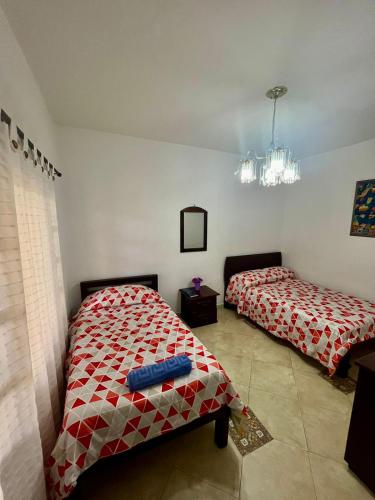 a bedroom with two beds and a mirror at Finca Hotel Andaquies in Armenia