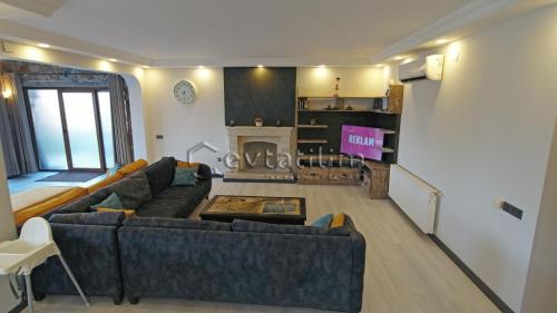 a living room with a couch and a fireplace at Villa Torba Bay by EvTatilim in Torba