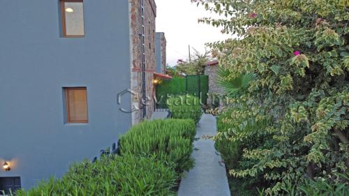 a walkway leading to a building with plants at Villa Torba Bay by EvTatilim in Torba