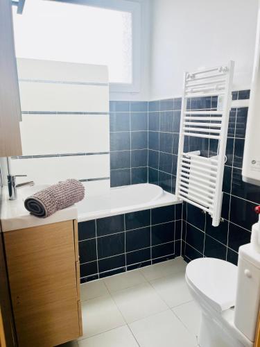 une salle de bain avec une baignoire, un lavabo et des toilettes dans l'établissement Grand studio aux portes de Genève, à Ambilly