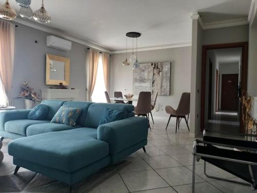 salon z niebieską kanapą i stołem w obiekcie Antonio's BnB w mieście Casalnuovo di Napoli