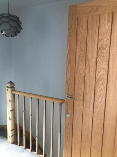 a wooden door in a room with a staircase at Penarth refurbishment in Cardiff