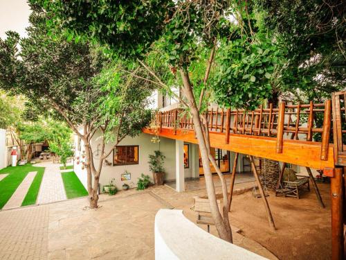 a tree house with a wooden deck in a yard at Little Forest Garden Retreat in Windhoek
