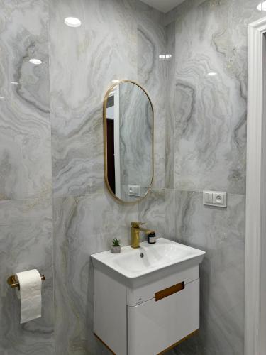 a bathroom with a white sink and a mirror at City new appartment in Arabkir