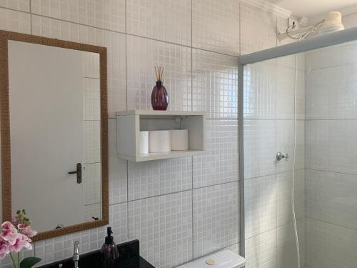 a bathroom with a shower and a sink and a mirror at Riviera Massaguaçu in Massaguassu