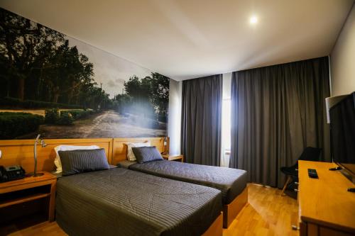 a hotel room with two beds and a painting on the wall at Burguezia do Leitão in Casal Comba