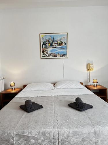 a bed with two black hats on top of it at Family Majčica - villa Malo Misto in Klek
